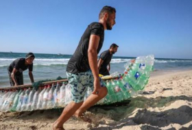 وسط استغراب الناس من حوله.. فلسطيني يُبحر على 700 عبوة بلاستيكية ليصطاد رزق عائلته، صور وفيديو